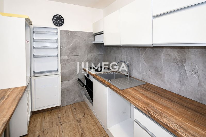 Konyha egy 3 szobás lakásban fa dekor padlóval és modern készülékekkel.