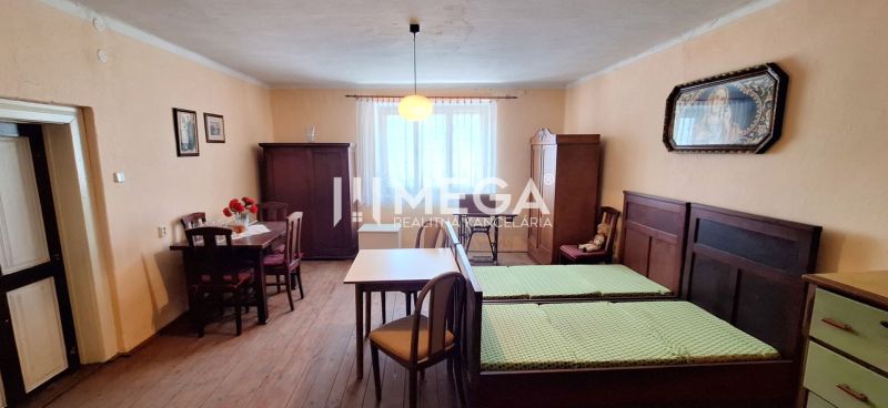 Szoba egy családi házban fa dekorációval, antik bútorokkal és egyszerű világítással.