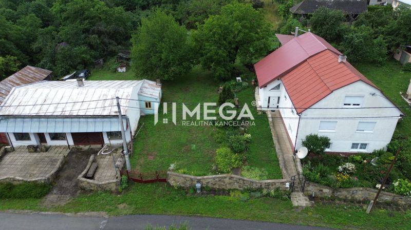Egy piros tetős ház Oľšinkovban, az Oľšinkov utcában, kerttel körülvéve. Telek - lakóövezet.