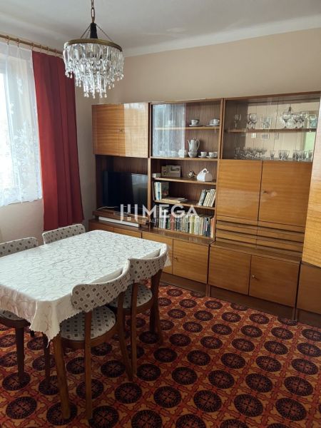 Ebédlő egy családi házban retro bútorokkal, szőnyeggel, csillárral, függönyökkel.