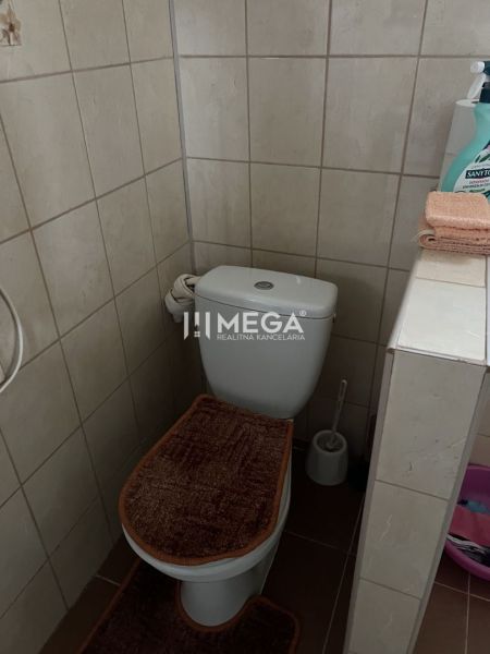 Fürdőszoba családi házban WC-vel, padlólap és fali csempe.