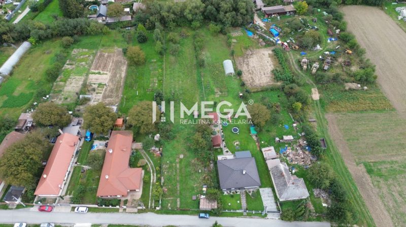 Lakóterületek Veľká Ida községben, Gomboš, zöldövezet és szomszédos házak által körülvéve.