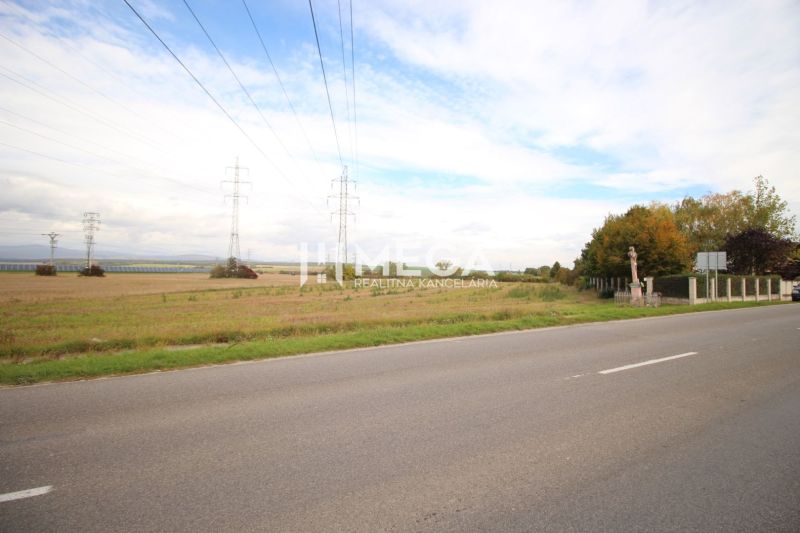 Kiterjedt lakóterületek az út mellett, Mokrance községben, elektromos vezetékekkel.