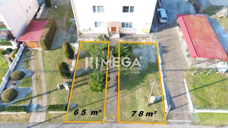 Két lakótelek Humennéban, egy többszintes épület mellett, 65 m² és 78 m² területtel.