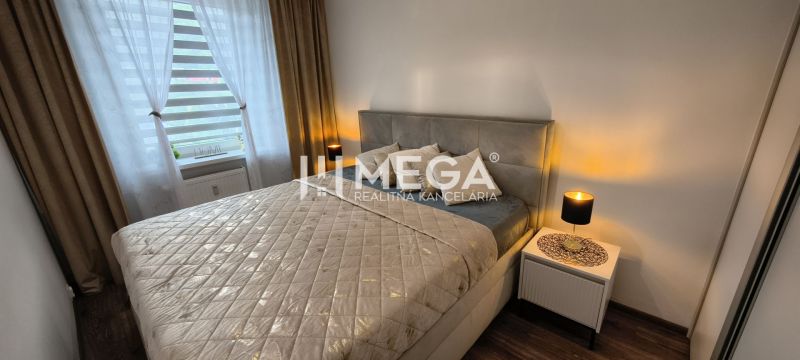 Hálószoba egy háromszobás lakásban ággyal, éjjeliszekrényekkel és fa dekorú padlóval.
