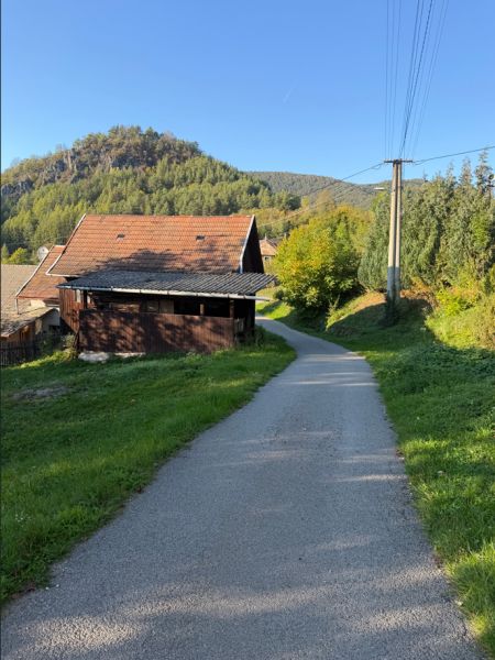 A Košecké Podhradíban az út házak mellett vezet, zölddel és dombokkal szegélyezve. Telek - lakóövezet.