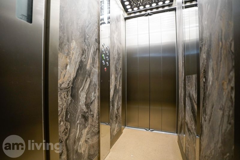 Lift belső tér márványfalakkal és tükrökkel egy egyszobás lakásban.
