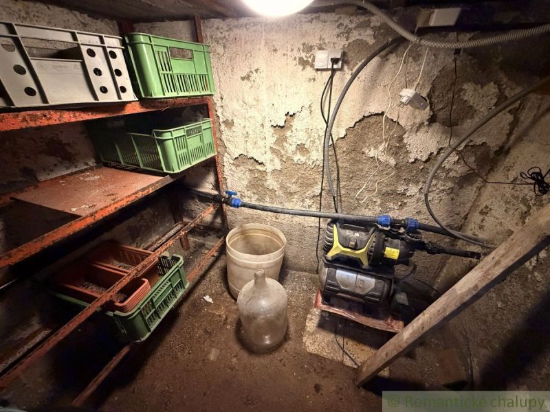 Tárolóhely polcokkal és műanyag ládákkal a házikóban.