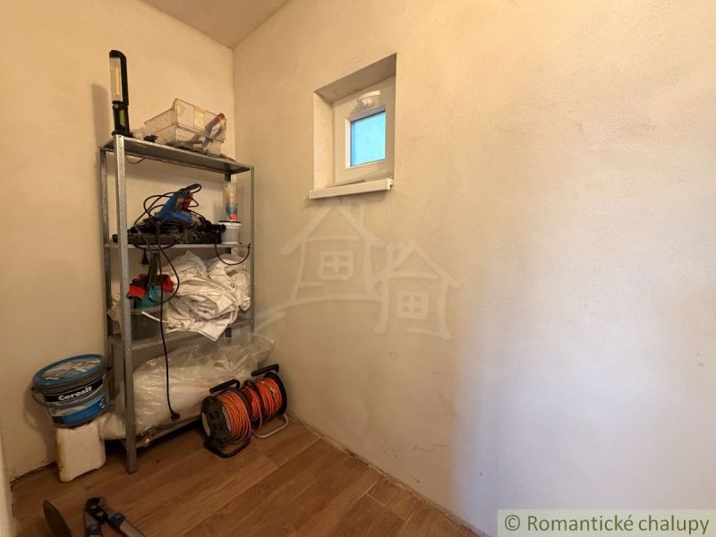 Tároló polc szerszámokkal és fa mintázatú padló a faházban.