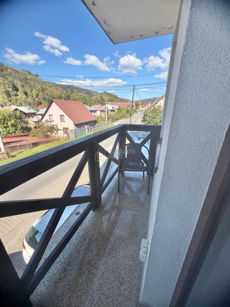 Erkély kilátással a központi utcára Oščadnicában, zölddel és házakkal körülvéve, 1 szobás lakás.