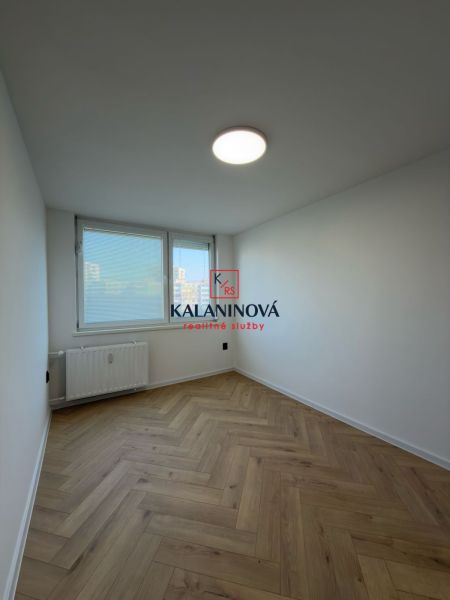 Világos szoba egy 4 szobás lakásban fa mintázatú padlóval.