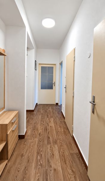 Folyosó egy 3 szobás lakásban fa dekor padlóval és szekrénnyel.