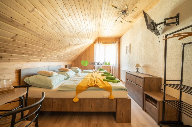 Szoba fa burkolattal, franciaággyal, TV-vel és fa dekorációjú padlóval. Szállodák és panziók.