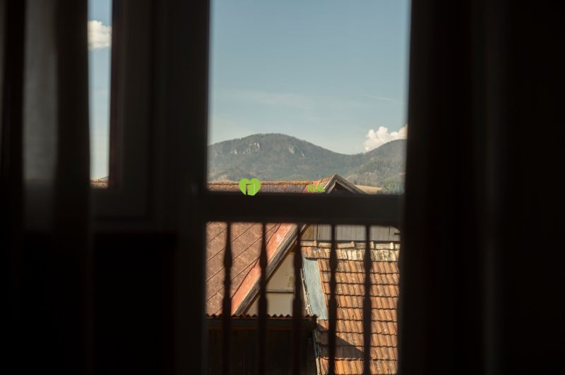 Kilátás az ablakból a tetőkre és a hegyekre Liptovský Michalban, szállodák és panziók.