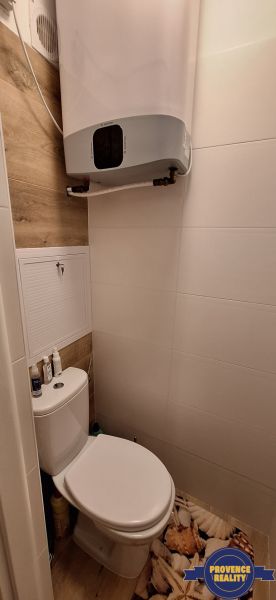 WC fa hatású padlóval egy háromszobás lakásban.