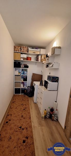 Kompakt szoba polcokkal, szekrénnyel és fa dekorációjú padlóval egy háromszobás lakásban.