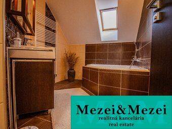 Fürdőszoba családi házban káddal és fa dekorációval a bútorokon.