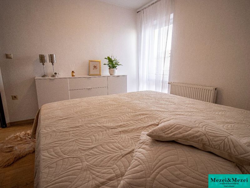 Hálószoba fehér bútorokkal és dekoratív kiegészítőkkel egy családi házban.