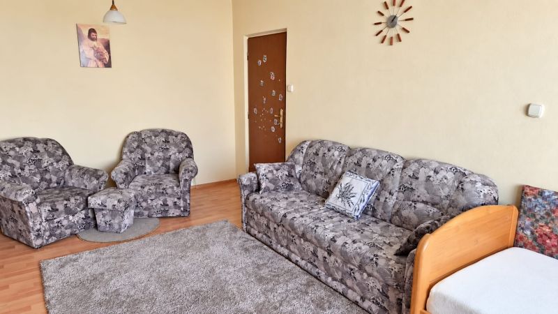 Kényelmes nappali mintás kanapéval egy háromszobás lakásban.
