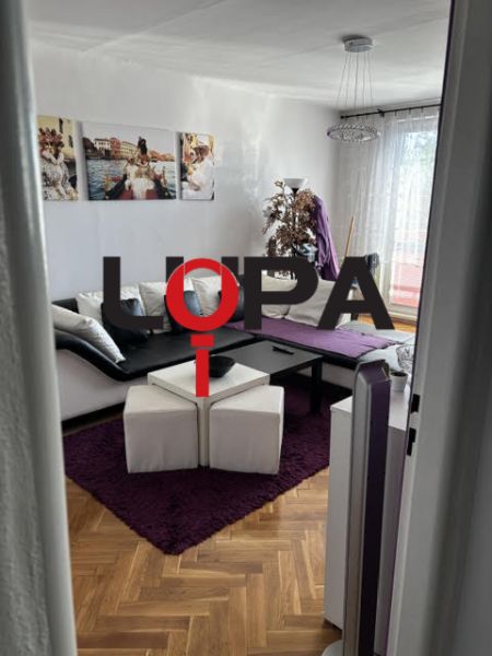 Kényelmes nappali fa hatású padlóval a népszerű kétszobás lakásban.