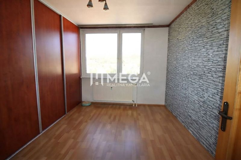 Szoba fa dekor padlóval és beépített szekrénnyel egy háromszobás lakásban.
