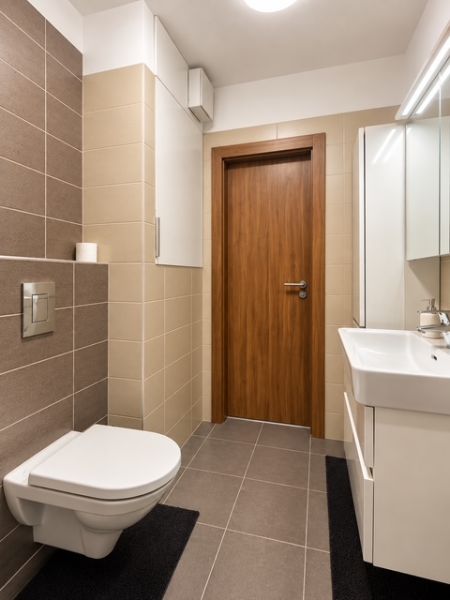 Fürdőszoba egy kétszobás lakásban csempével és fali WC-vel.