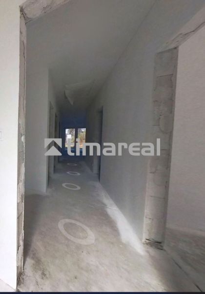 Egy családi ház folyosója befejezetlen padlóval és csupasz falakkal.