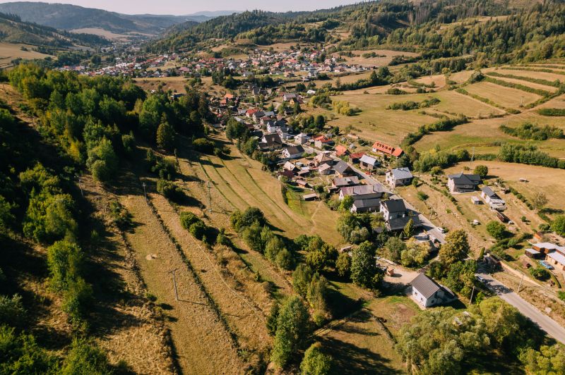 Légi felvétel a házakról és rétekről a Feketebalogon, az Iskola utcában, amelyet rekreációs területek vesznek körül.