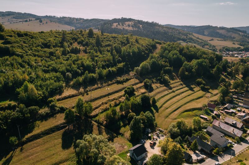 Légi felvétel a zöld dombokról és házakról a Čierny Balog-i Školská utcában.