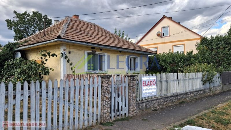 Családi ház Tornyosnémetiben téglatetővel és színes kerítéssel.