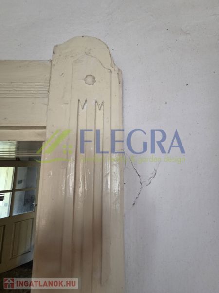 Családi ház belső tere repedéssel a falon az ajtó mellett.