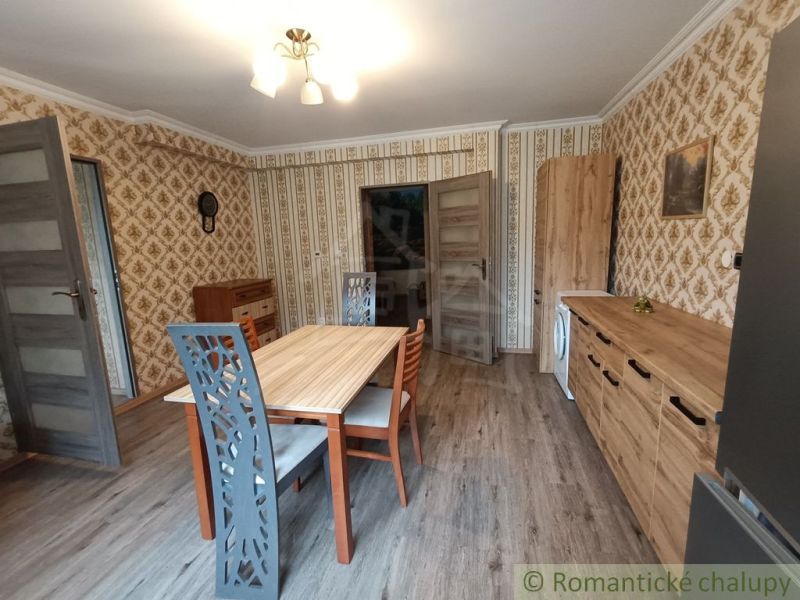 Ebédlő egy családi házban mintás tapétával és fa dekorációjú padlóval.