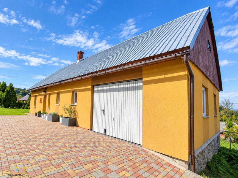 Sárga családi ház a Košariská utcában, Oščadnicában, színes burkolattal.