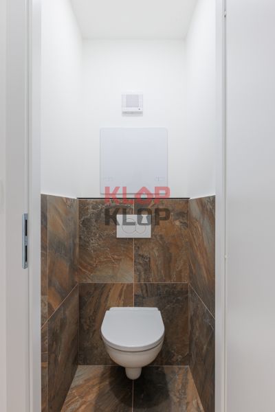 WC barna csempével egy kétszobás lakásban.