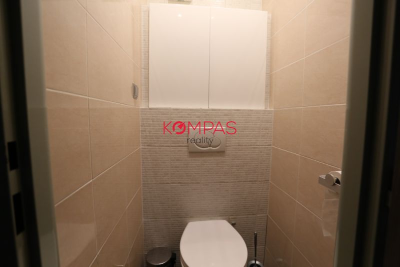 Fürdőszoba függesztett WC-vel és csempékkel egy kétszobás lakásban.