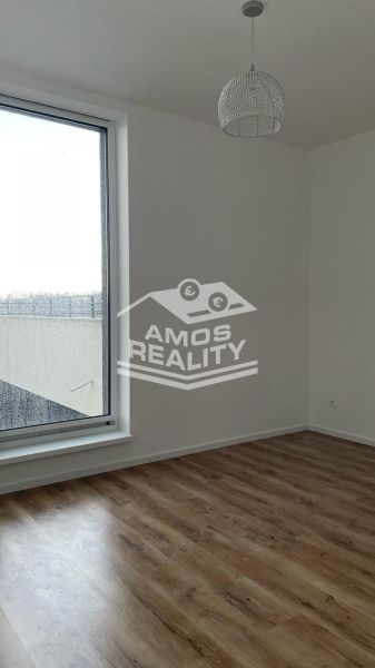 Szoba egy kétszobás lakásban nagy ablakkal és fa dekorációjú padlóval.