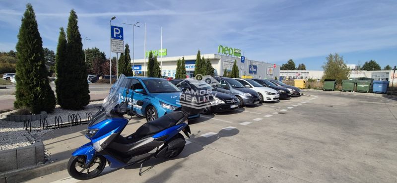 Parkoló autókkal és motorral a bevásárlóközpontnál, Malackán, a Javorová utcában.