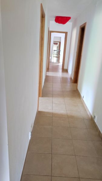 Folyosó egy családi házban csempével és fehér falakkal.