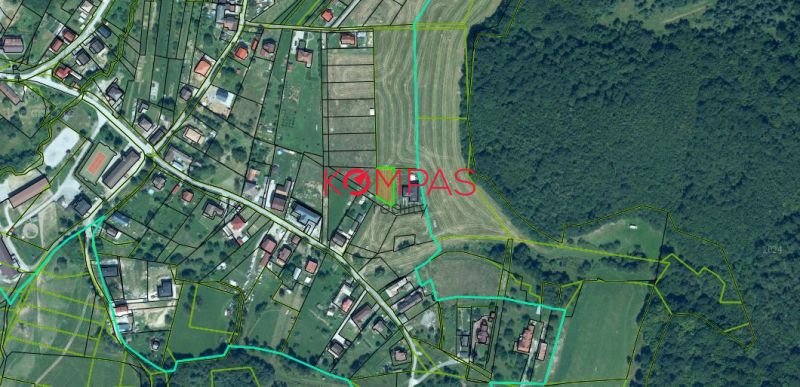 Légi felvétel a Podzámčok községben található lakóterületekről, amelyeket zöldterület és parcellák vesznek körül.