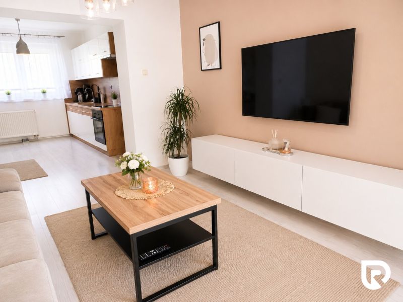 Nappali egy kétszobás lakásban fa dekor padlóval és modern bútorokkal.