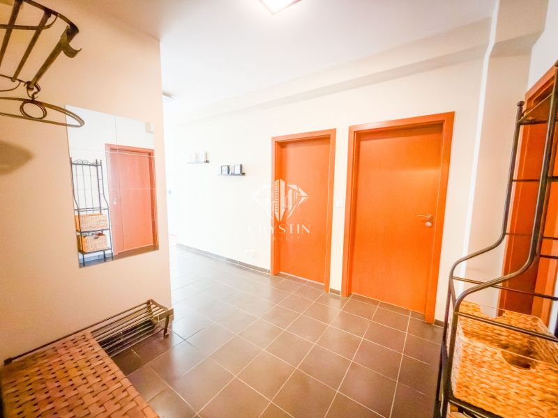 Folyosó egy 3 szobás lakásban tükörrel, fekete csempével és faajtókkal.