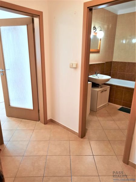 Folyosó csempével és kilátással a fürdőszobára egy kétszobás lakásban.