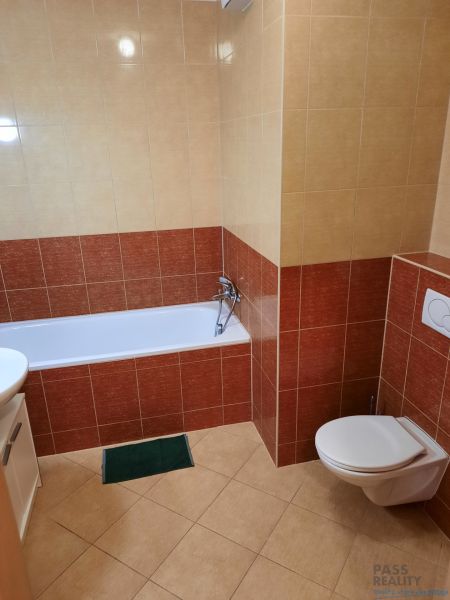 Fürdőszoba káddal és WC-vel egy kétszobás lakásban, kerámia burkolatokkal körülvéve.