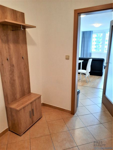 Előszoba egy kétszobás lakásban, akasztós fallal és kilátással a nappalira étkezővel.