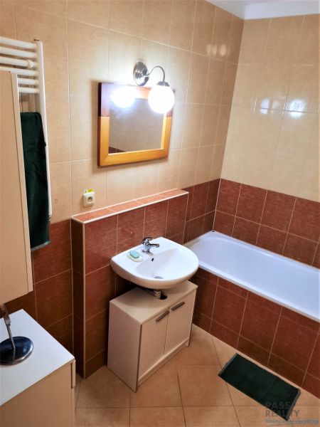 Fürdőszoba mosdóval, káddal és szekrénnyel egy kétszobás lakásban.