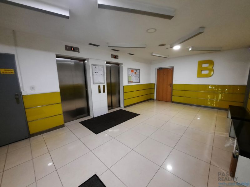 Kétliftű belső tér, sárga falakkal és világos csempékkel egy kétszobás lakásban.