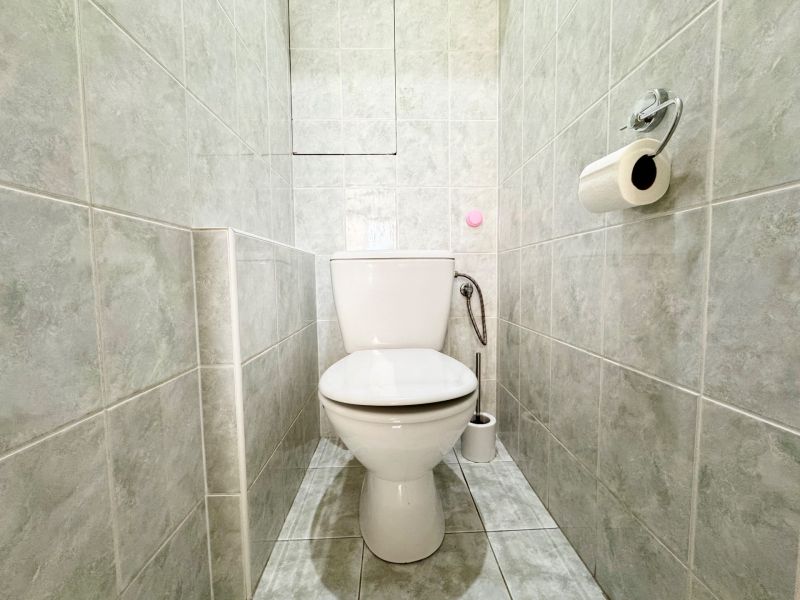 WC csempével és WC-papírral egy háromszobás lakásban.