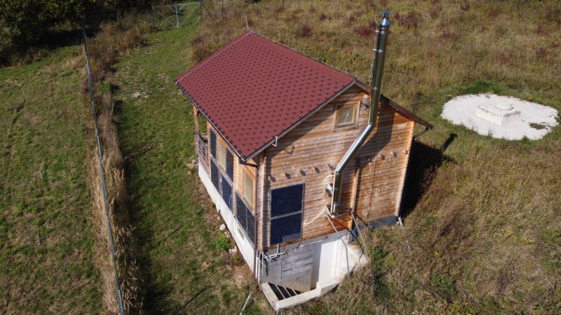Faház Felsőbreznicén, lejtőn, fa burkolattal és napelemekkel.