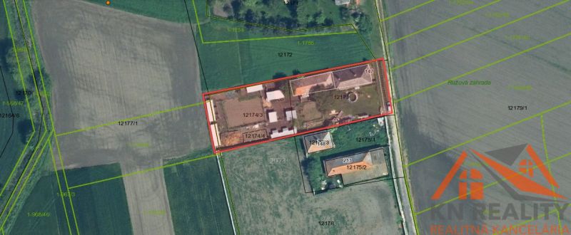 Családi házak légi felvétele Komáromban, amelyeket mezők és növényzet vesz körül.