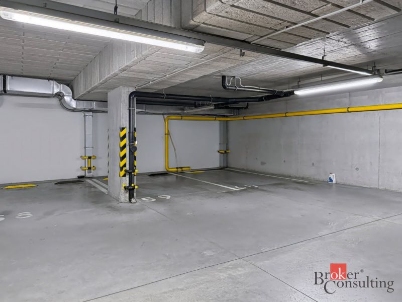 Parkolóhely a mélygarázsban színesen jelölt padlón.